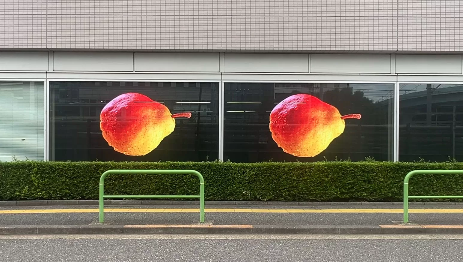 Façade vitrée d'un bâtiment diffusant une création géante sur LED transparente